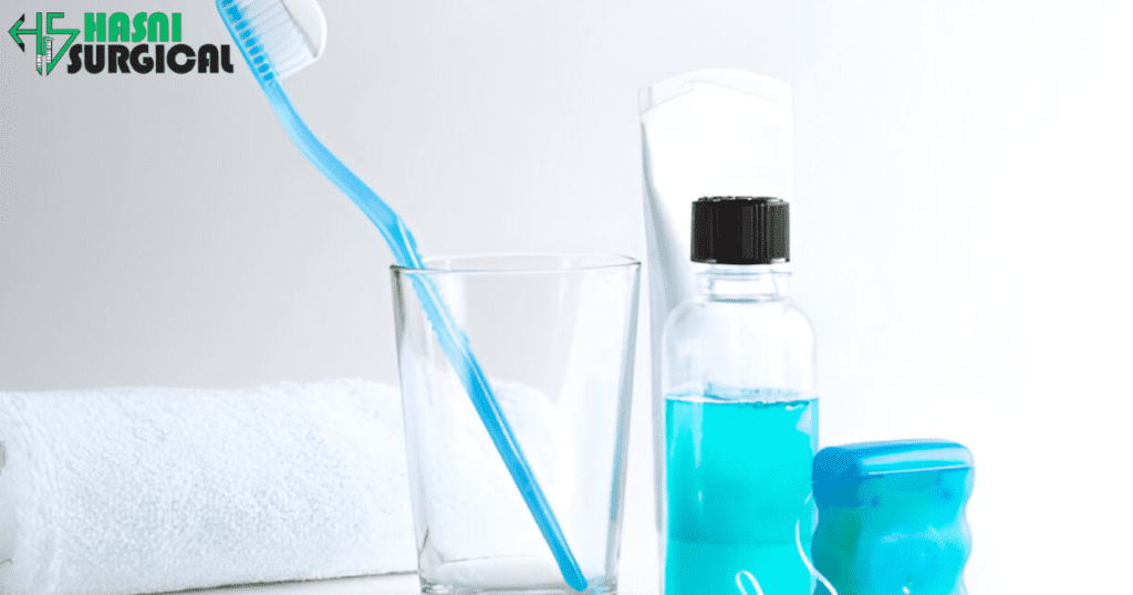 A toothbrush in a cup. Alongside a bottle of mouth wash, floss and towel.