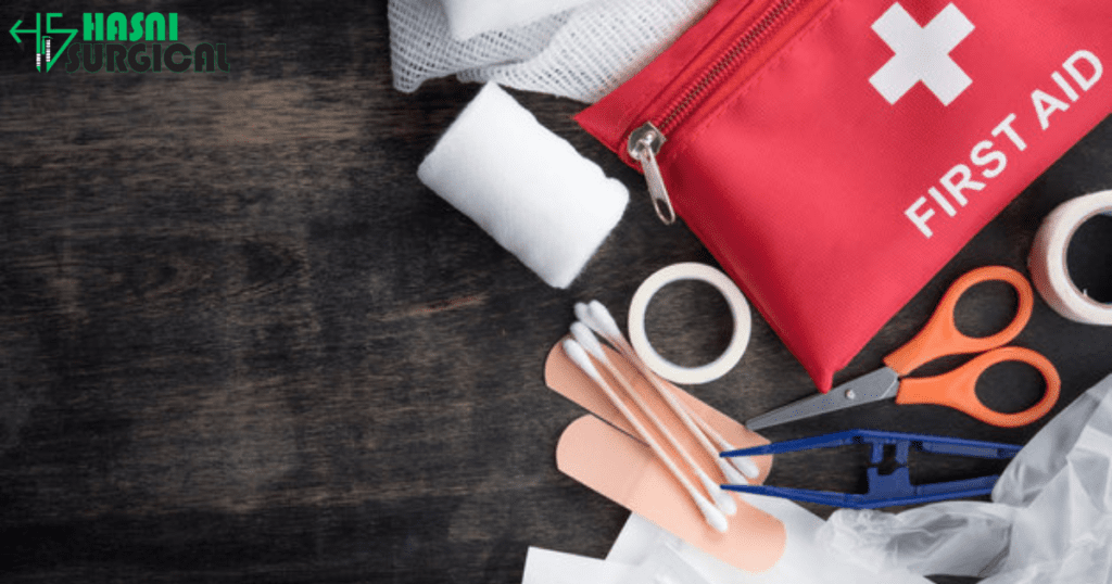 A first aid kit with various first aid supplies lying around it, like scissors, bandages, and more.