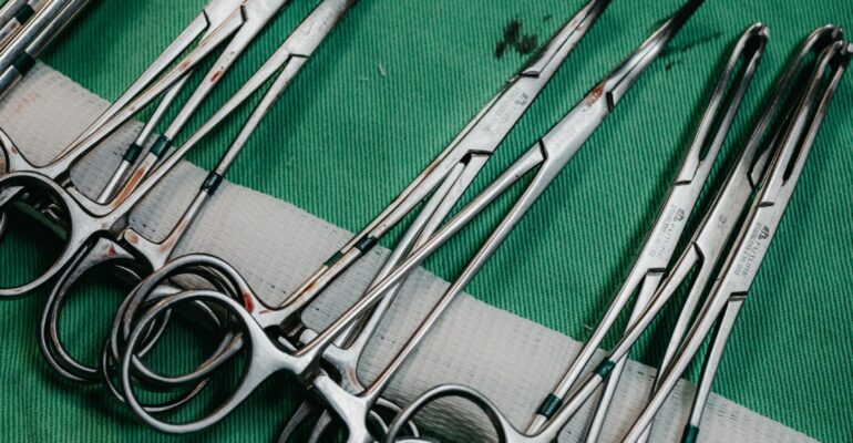 Surgical thinning scissors on sterile green cloth - Hasni Surgical Pakistan manufacturer