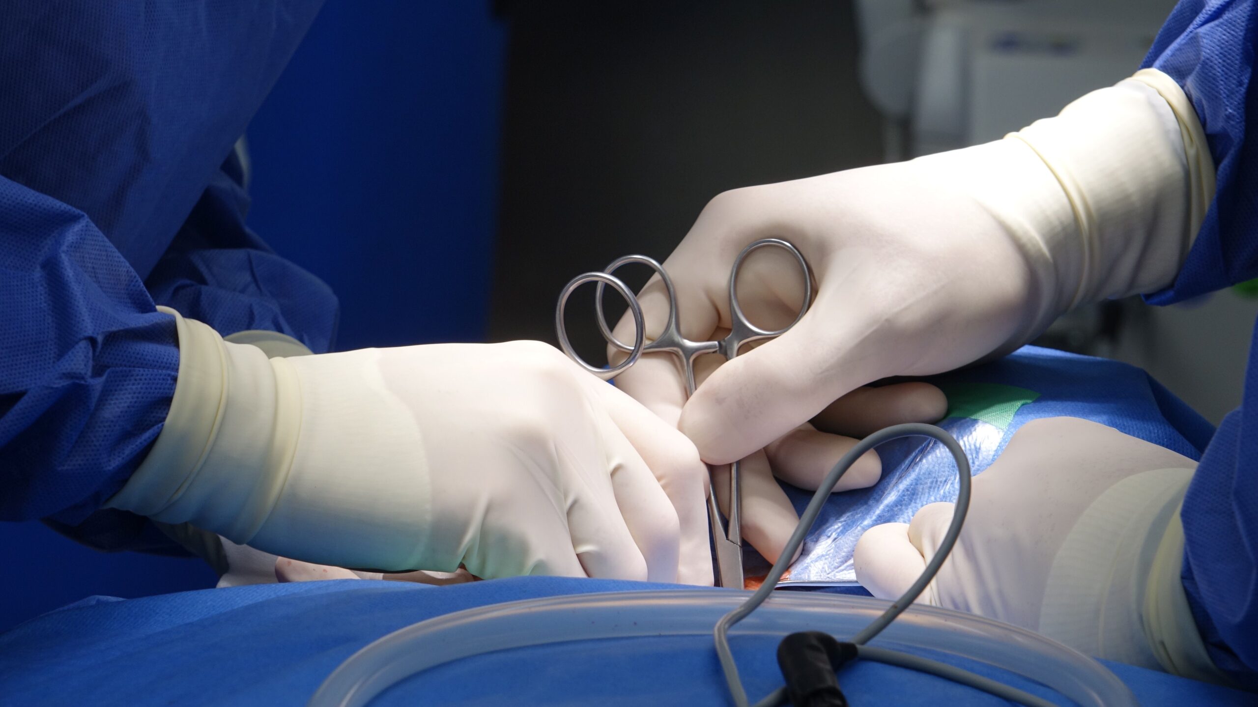 Surgeons in sterile gloves performing precise spinal fixation surgery in hospital operating room