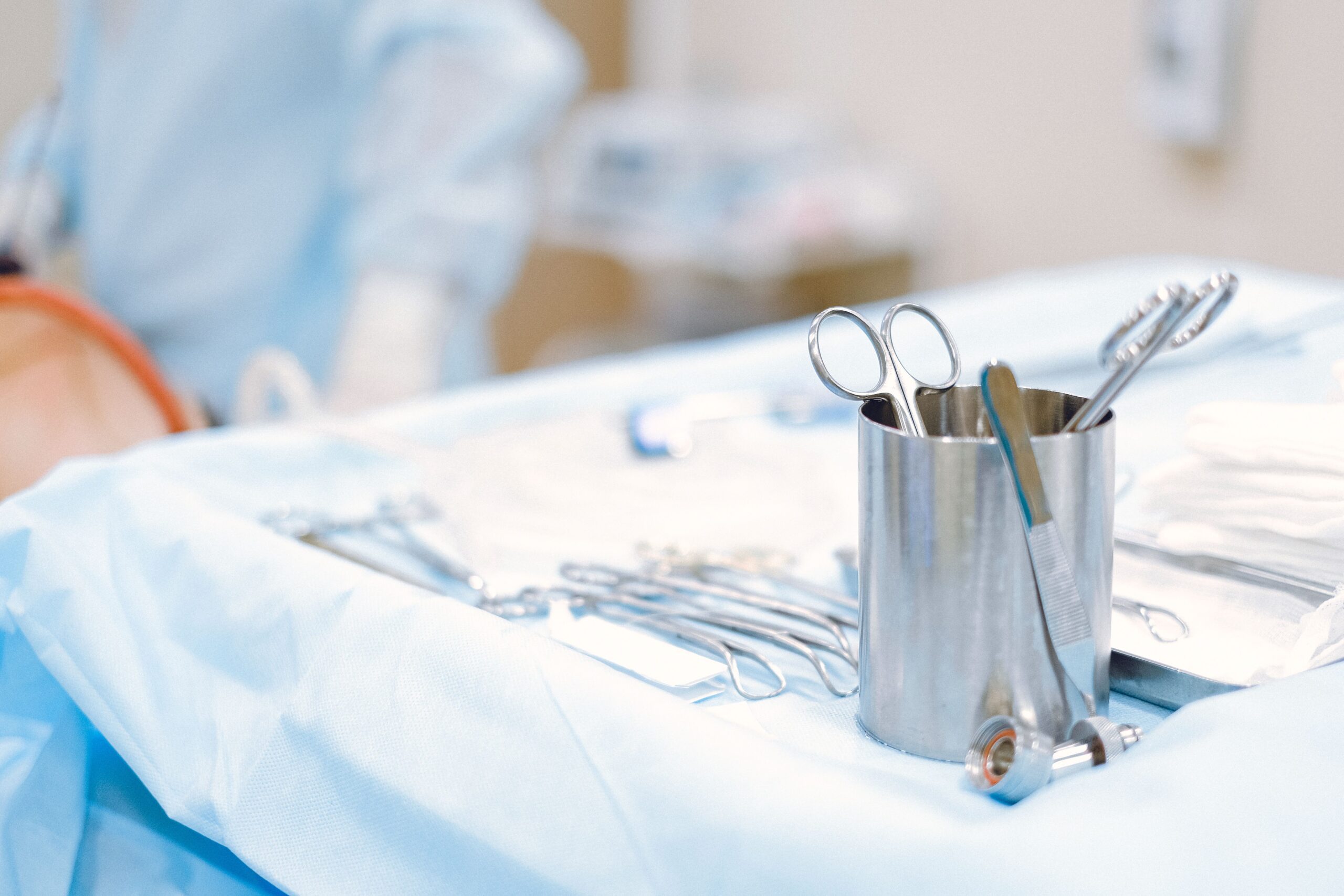 Surgical tools laid out in operating room including scalpel forceps scissors for hand surgery procedure