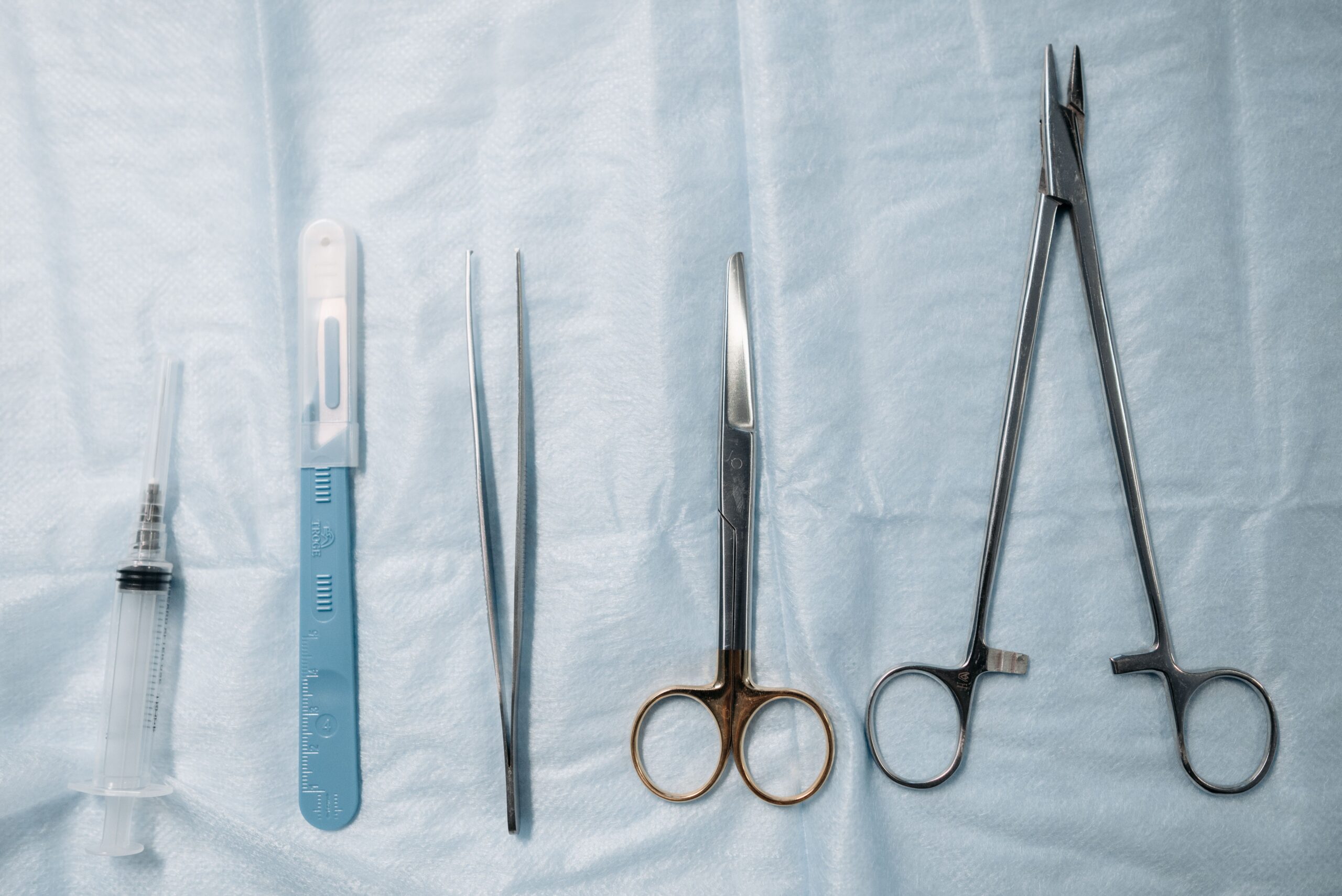 Surgical scissors and instruments flat lay on sterile blue cloth - stainless steel