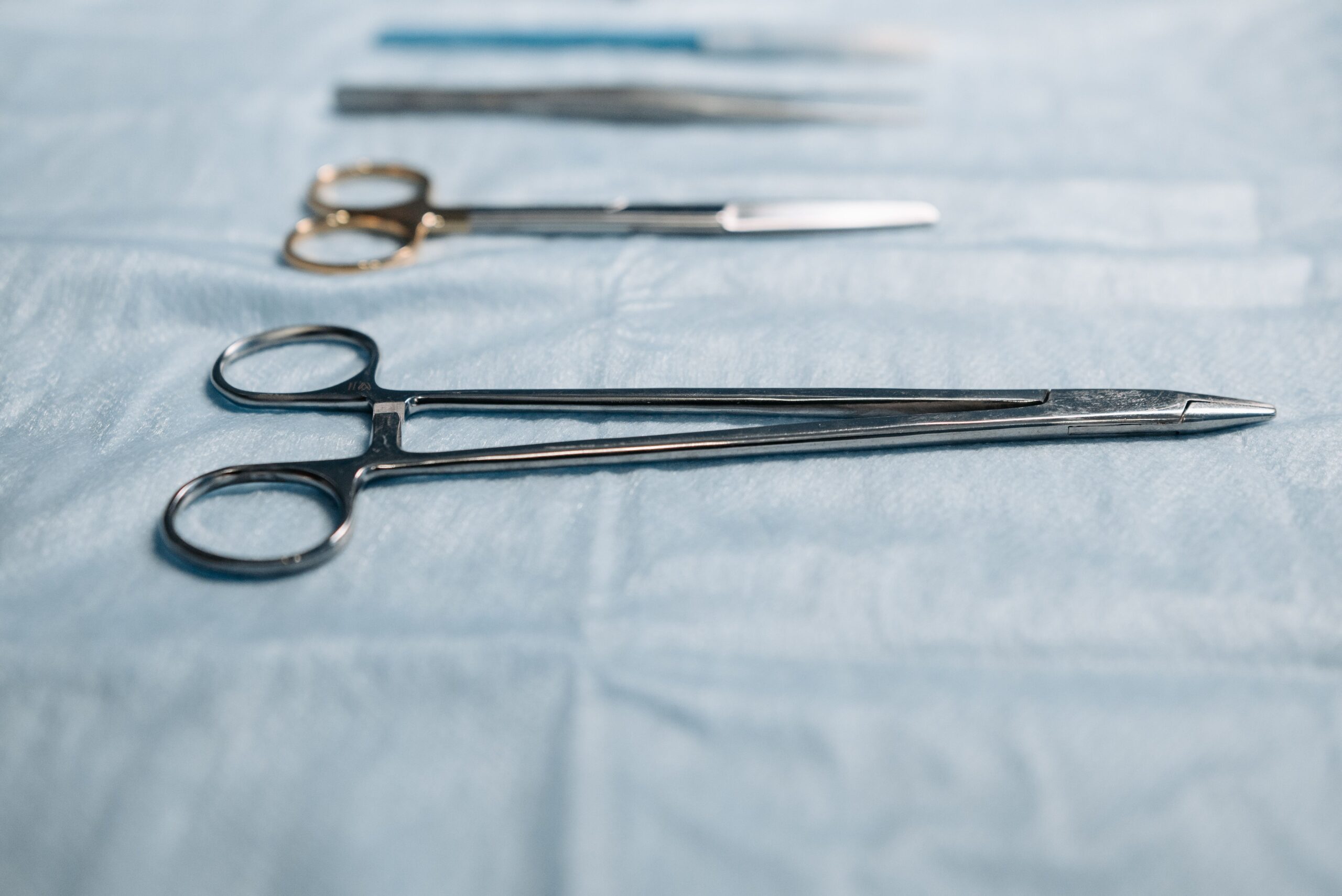 Silver needle holder surgical instrument close-up in medical operating room setting