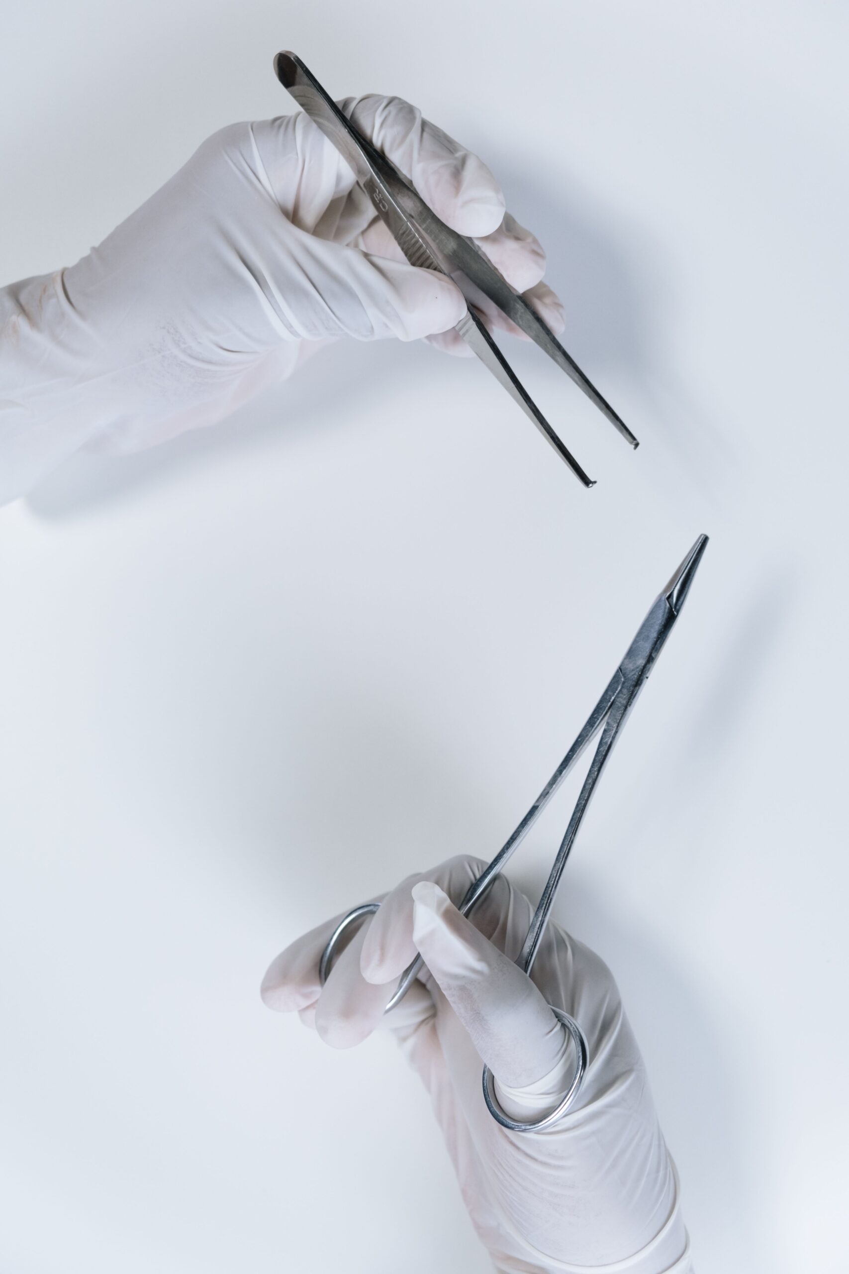 Titanium Surgical Forceps — Hasni Surgical Premium Instruments Titanium surgical forceps held by gloved hand in modern laboratory — premium precision instruments by Hasni Surgical Sialkot Pakistan